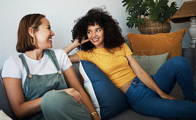 Buy stock photo Conversation, love and lesbian couple relaxing on a sofa in the living room talking and bonding. Happy, communication and young interracial lgbtq women speaking and resting together in lounge at home