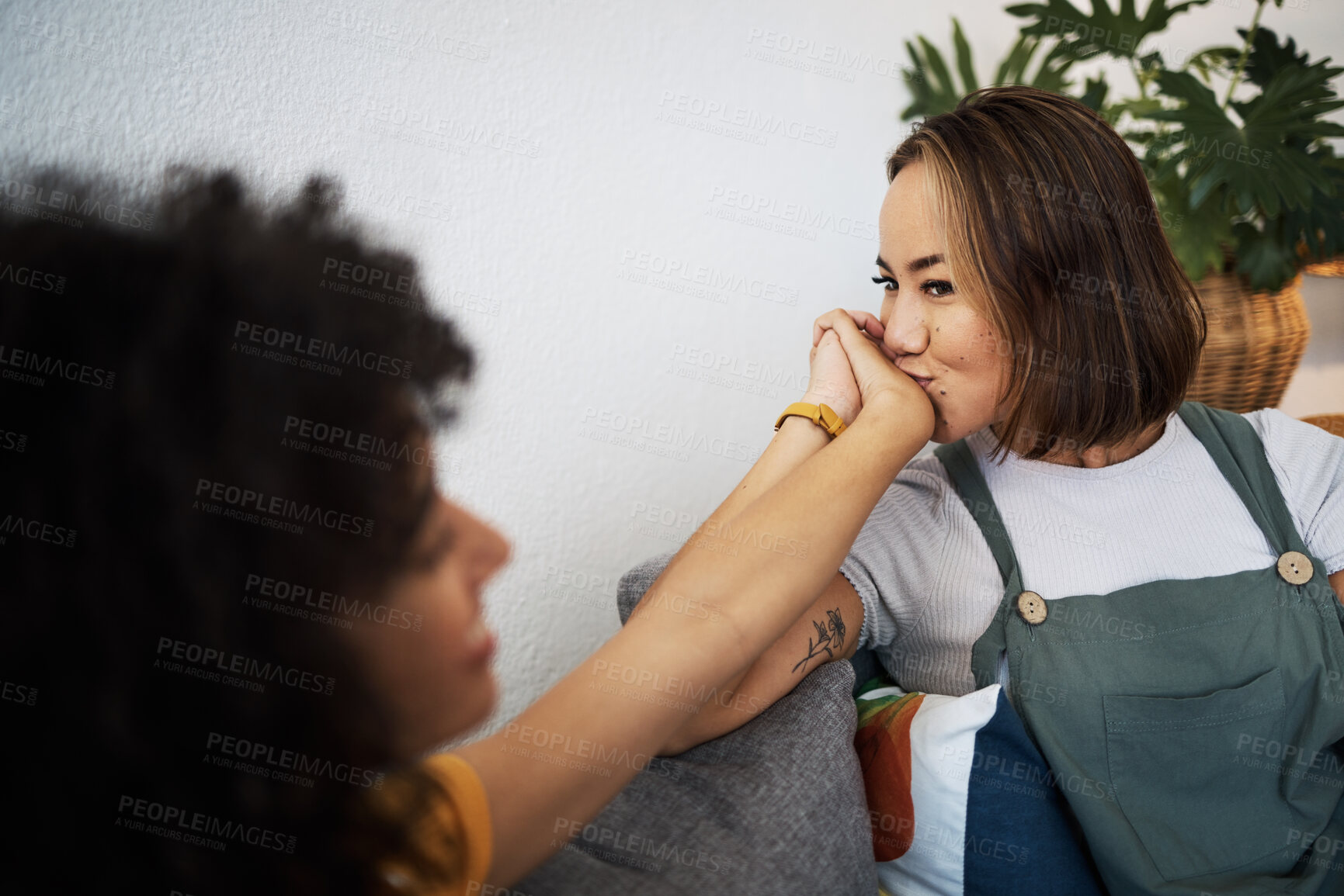 Buy stock photo Kiss, love and lesbian couple holding hands in home for romance, bonding and commitment for partner. Smile, intimate and gay woman together in living room for support, healthy relationship and LGBTQ