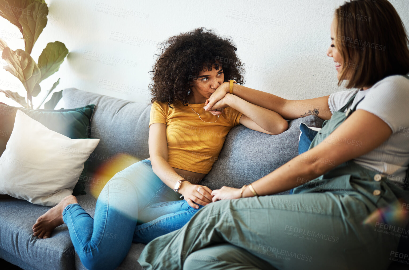 Buy stock photo Conversation, love and lesbian couple bonding on a sofa in the living room talking and relaxing. Happy, communication and young interracial lgbtq women speaking and resting together in lounge at home