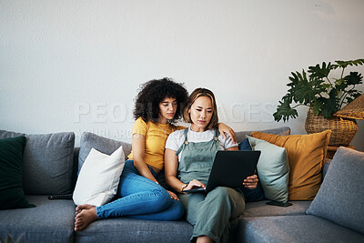 Buy stock photo Tablet, love and lesbian couple relaxing on a sofa in the living room networking on social media. Rest, digital technology and young lgbtq women scroll on mobile app or the internet together at home.