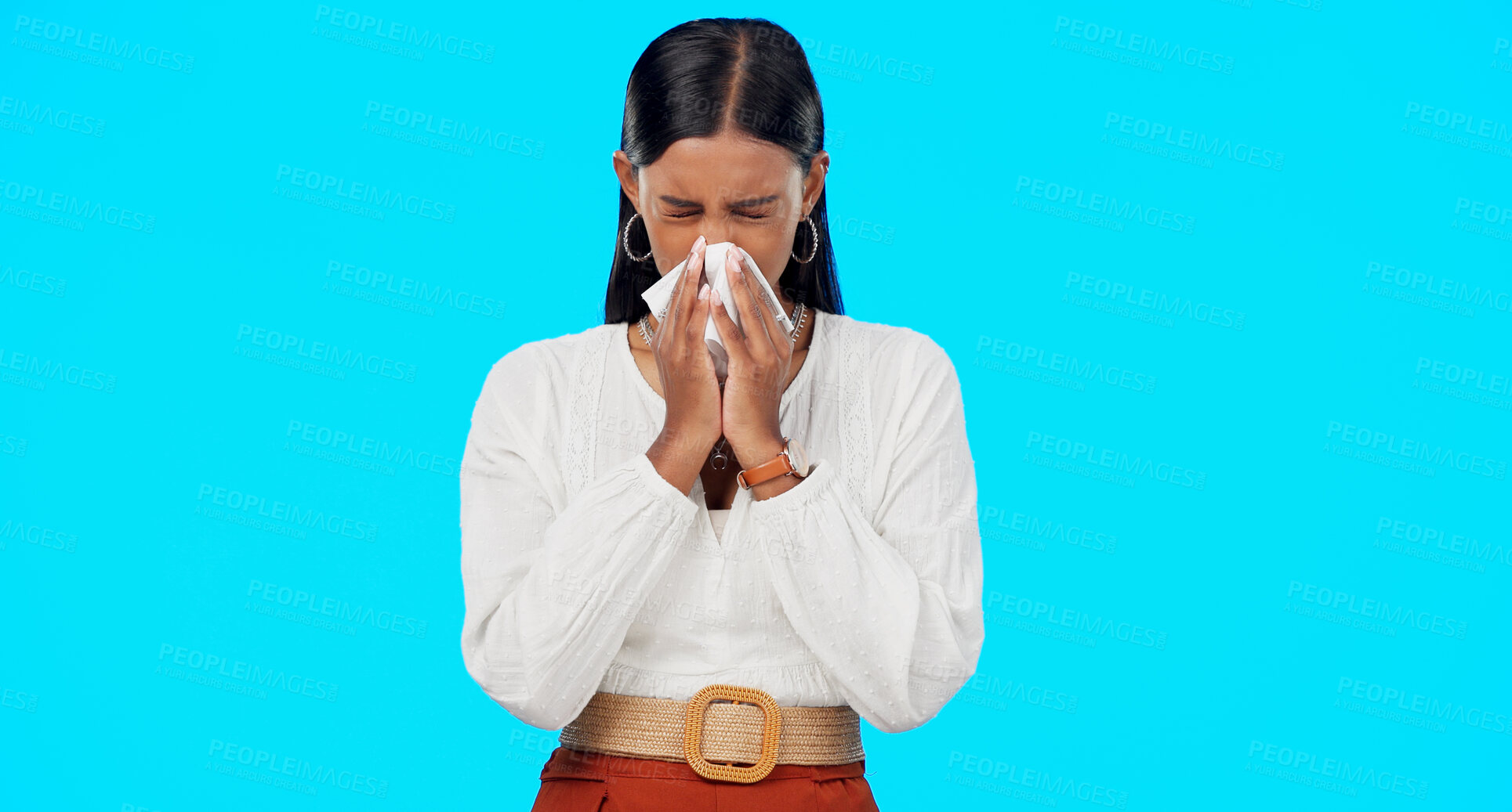 Buy stock photo Woman, blowing nose and sick with tissue in studio for allergies, dust or pollen  by blue background. Girl, sneeze and toilet paper with pain, virus and cold for healthcare, wellness and flu symptoms