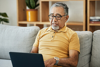 Buy stock photo Senior man, typing and laptop on sofa in home with online research in living room or streaming video, movies or tv show. Elderly, person or writing on computer in retirement for blog or communication