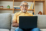 Typing, senior man and laptop on sofa in home with online research in living room or streaming video, movies or tv show. Elderly, person or writing on computer in retirement for blog or communication