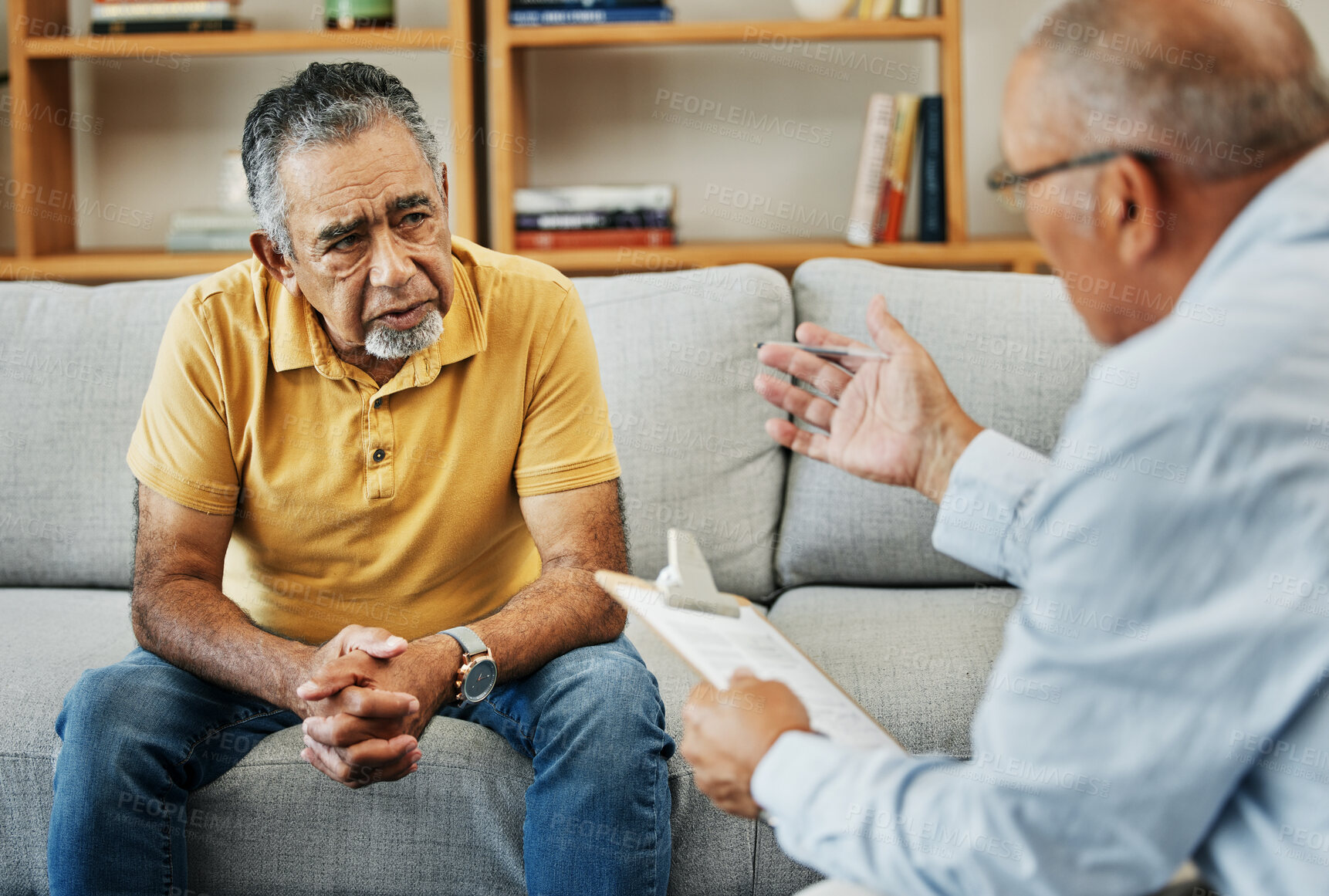 Buy stock photo Senior man talking to a psychologist at a mental health, psychology and therapy clinic for session. Psychological therapist with clipboard for counseling checklist with elderly male patient in office