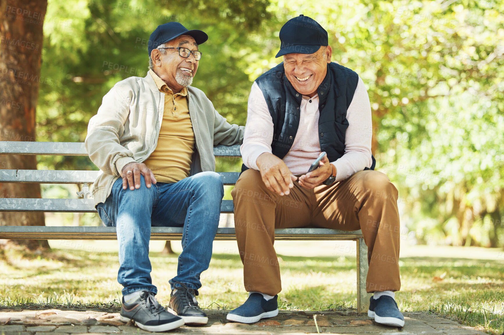 Buy stock photo Senior friends, funny and relax at park, talking and bonding outdoor in retirement. Happy elderly men sitting together in garden on bench, communication and laughing at comedy, joke or meme on phone