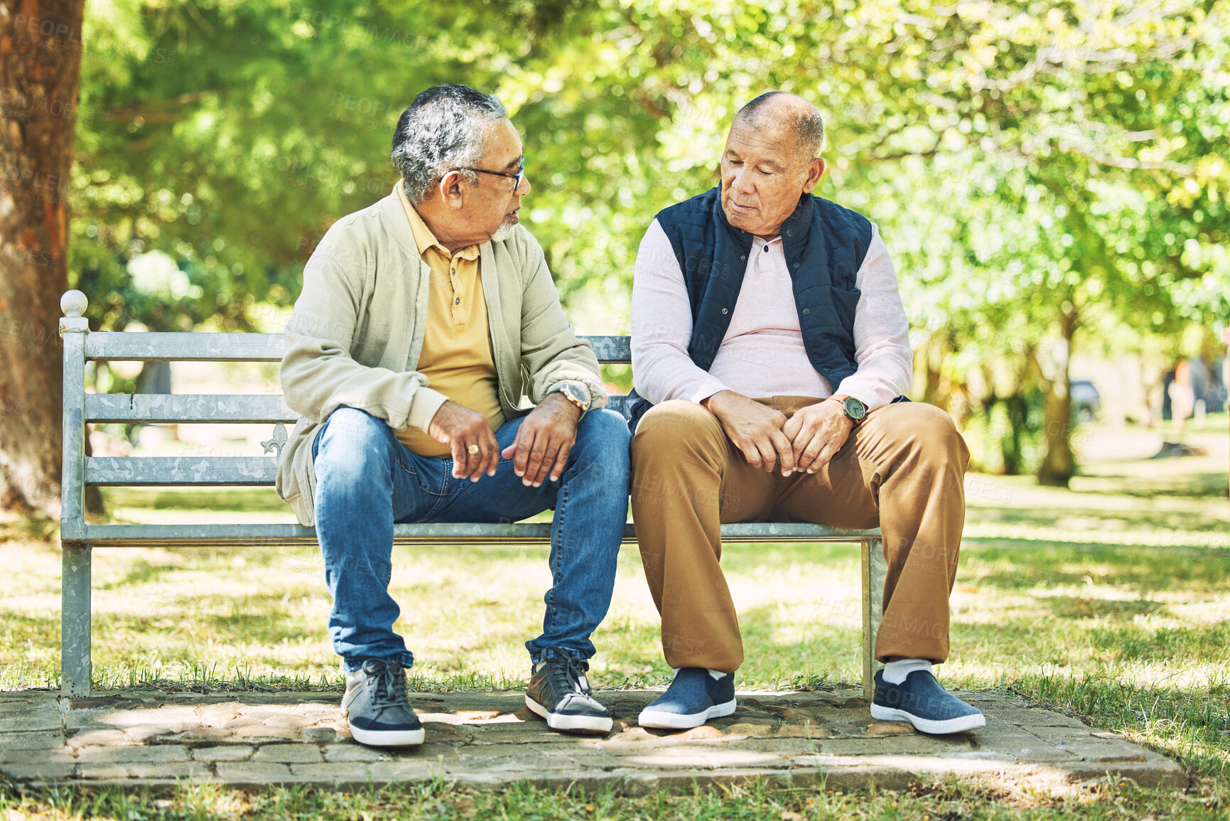 Buy stock photo Elderly friends, relax and men on park bench, talking and bonding outdoor. Senior people sitting together in garden, communication and serious conversation in nature for retirement in the morning