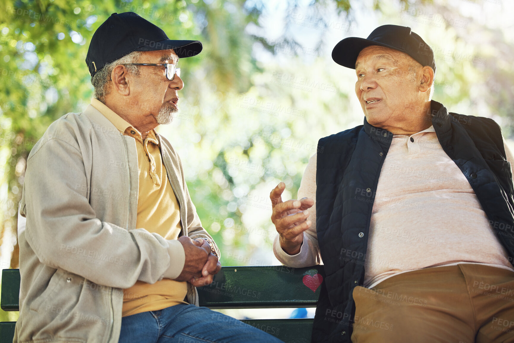 Buy stock photo Elderly men, park and communication with friendship, nature and conversation with bonding on bench. Diversity, closeup and old people with community for socialize, relaxation and discussion on life