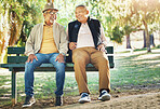 Senior friends, men and smile at park bench, talking and bonding outdoor to relax. Happy elderly people sitting together in garden, communication and conversation in nature for retirement in spring