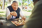 Happy, table and people in nature for chess, strategy and relax with a sport together. Smile, thinking and elderly or senior friends in retirement with games in a park on a board for competition