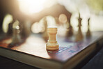 Closeup, chess and hand at park for competition, strategy and moving silhouette in sunshine. Person, vintage board game and outdoor for contest, battle and problem solving with challenge in summer