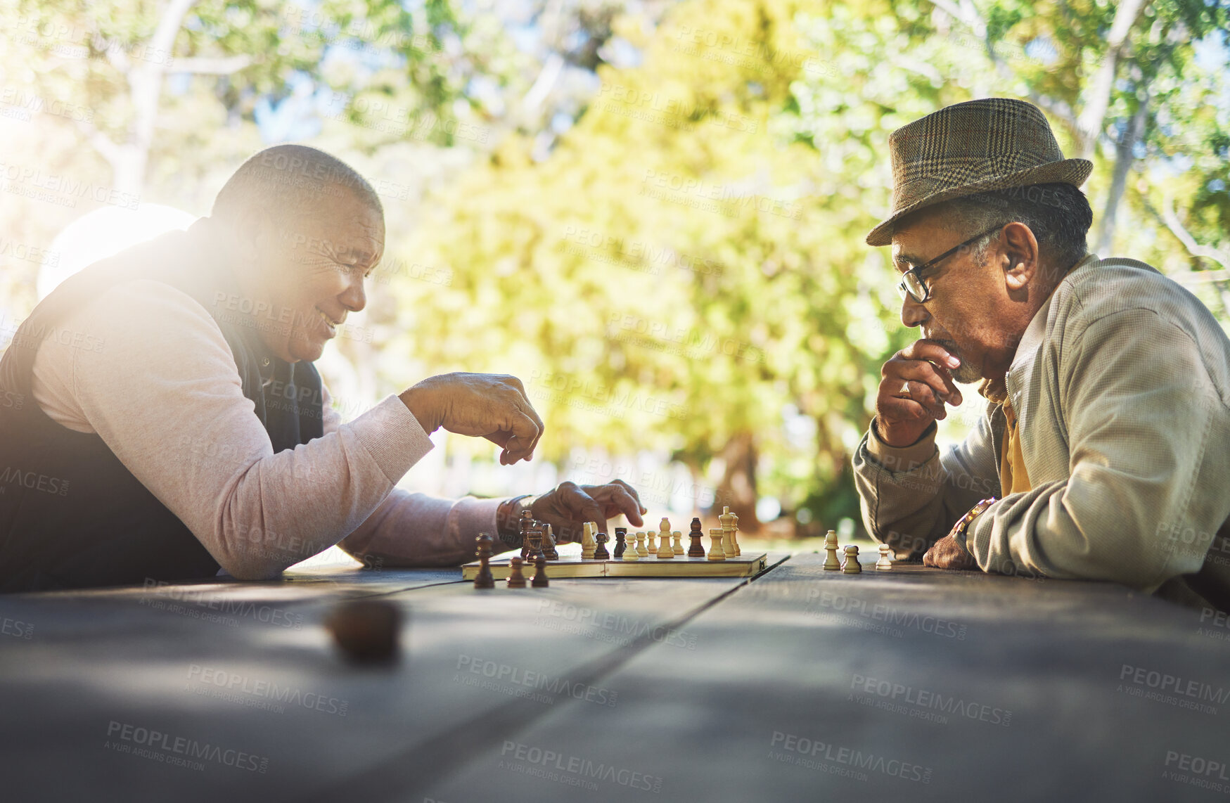 Buy stock photo Elderly men in park, chess game and strategy with competition or challenge, friends in retirement and intelligence. Thinking, planning and contest outdoor, concentration on boardgame and recreation