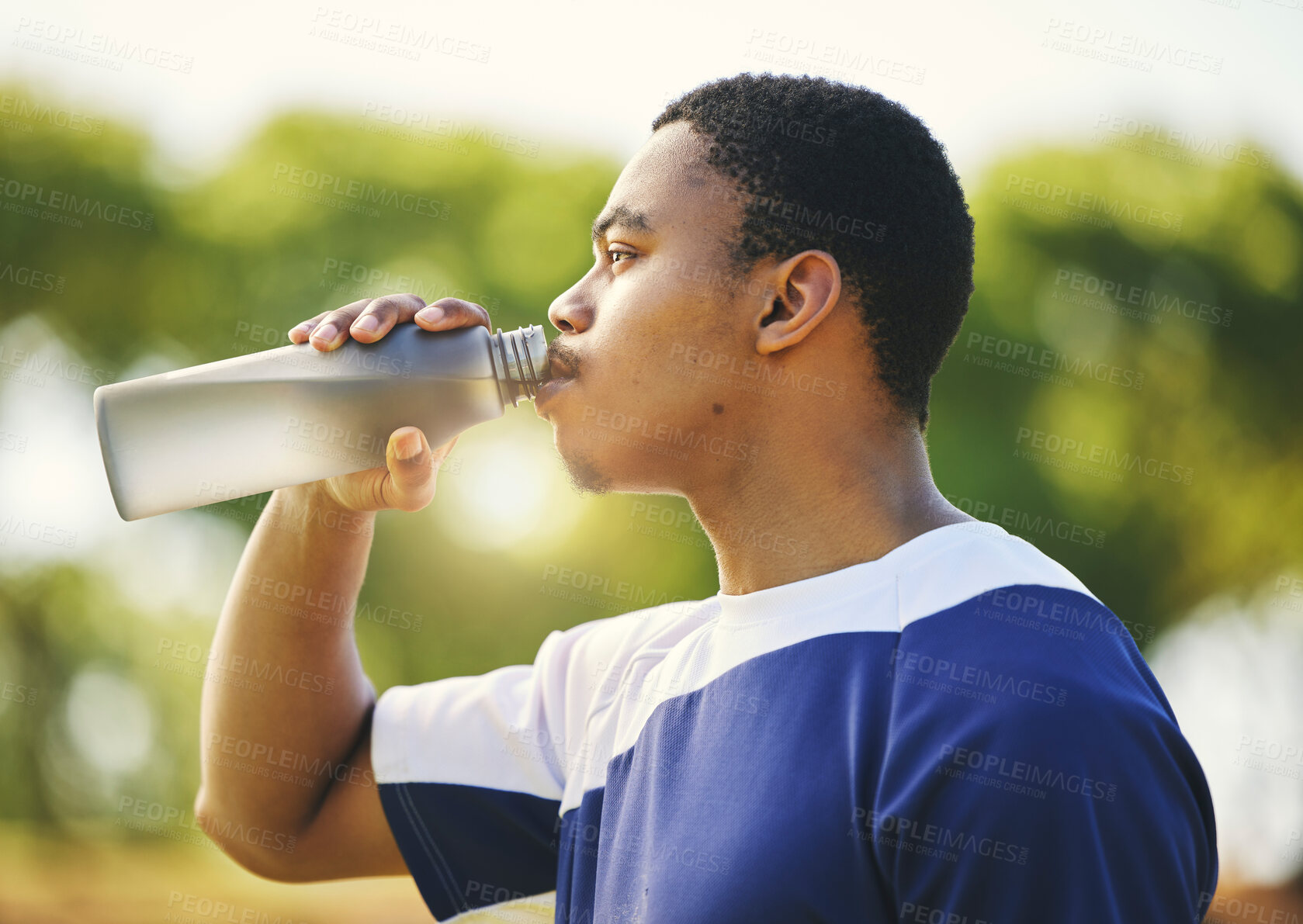 Buy stock photo Nature, relax or black man drinking water on break after exercise, workout or fitness training in park. Profile, healthy or thirsty African sports athlete with liquid bottle for wellness or hydration