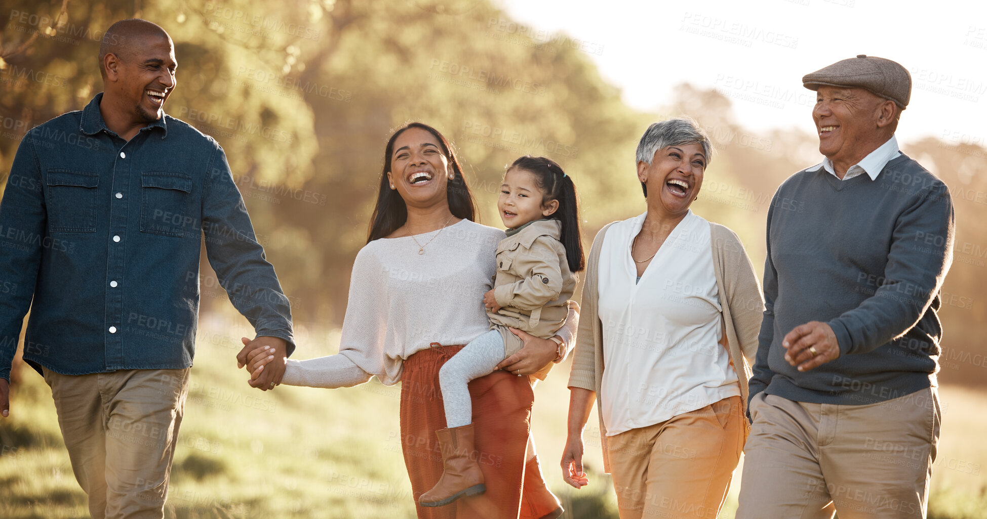 Buy stock photo Parents, child and happy outdoor with grandparents, holding hands and comic laugh with conversation. Men, women and kid on walk in nature, funny memory and bonding with love, vacation or care in park