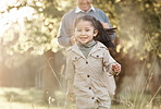 Running, nature and portrait of a child with grandfather for bonding, playing and love in a park. Smile, family and a girl kid with a senior man in a field for playful energy, freedom and care