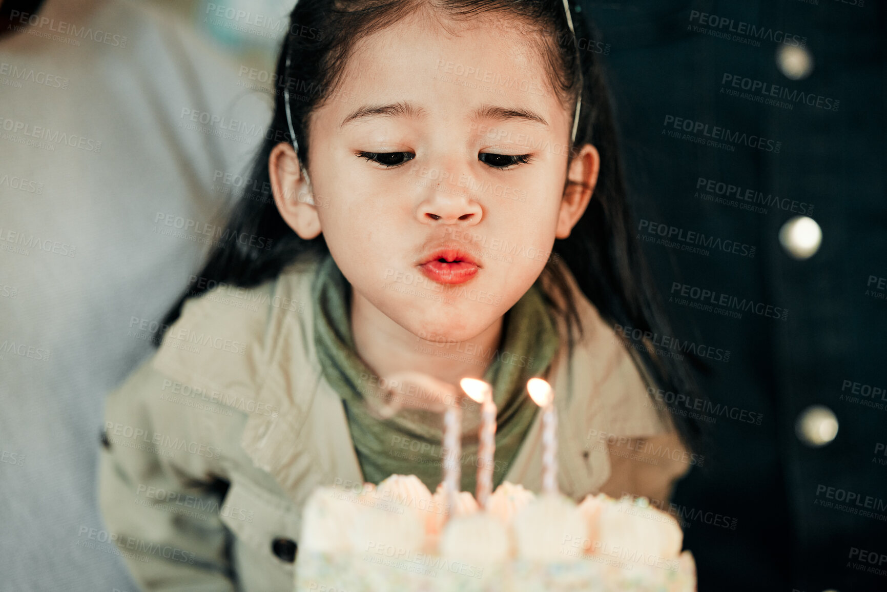 Buy stock photo Young girl, birthday cake and wish with candle at party, happy and celebration in home. Cute kid, smile and cream dessert with face of child with family, excited and special event in living room 