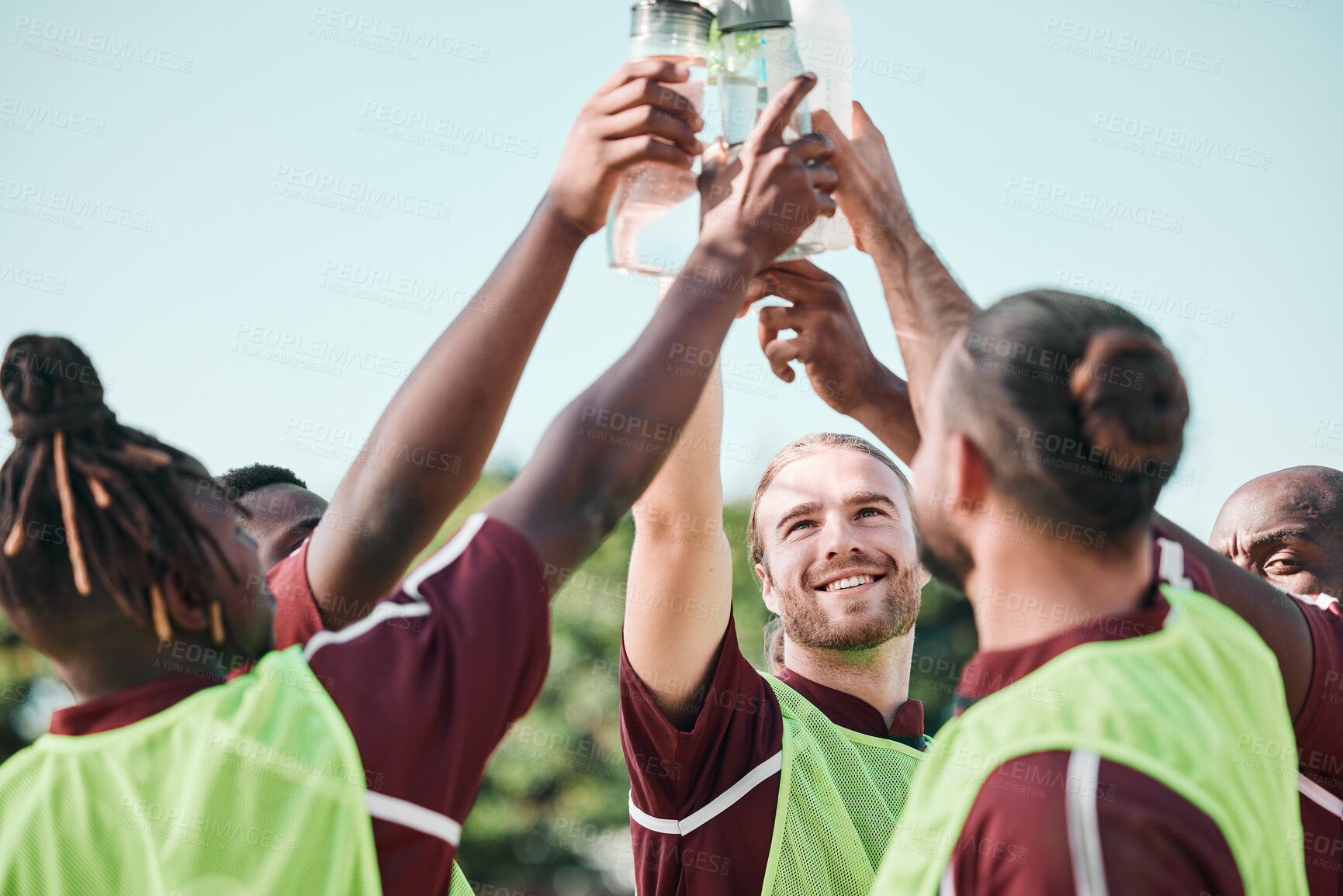 Buy stock photo Soccer team, water bottle and toast with teamwork, achievement and support on field. Fitness, workout and sport training of men group with smile and celebration at game outdoor with drink and cheers