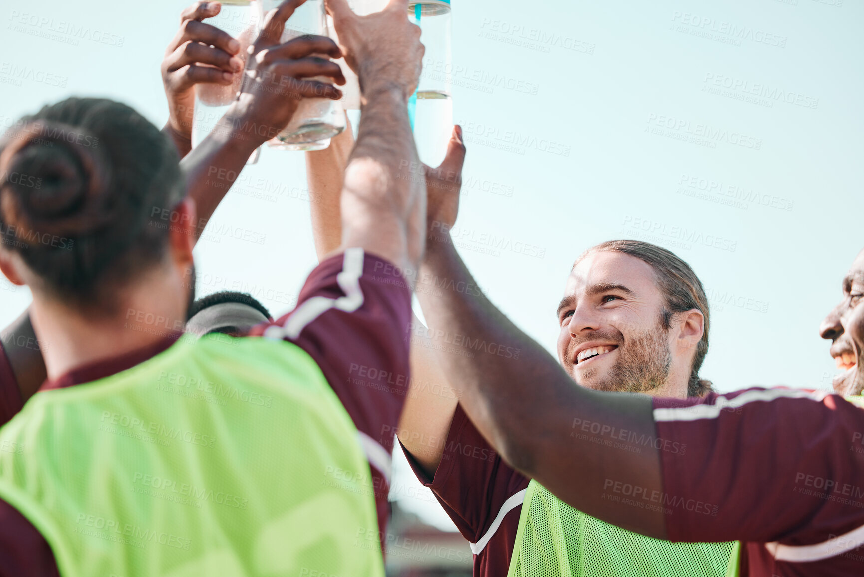 Buy stock photo Soccer team, water bottle and exercise cheers with teamwork, achievement and community on grass field. Fitness, workout and sport training of men group with smile and celebration from game with drink