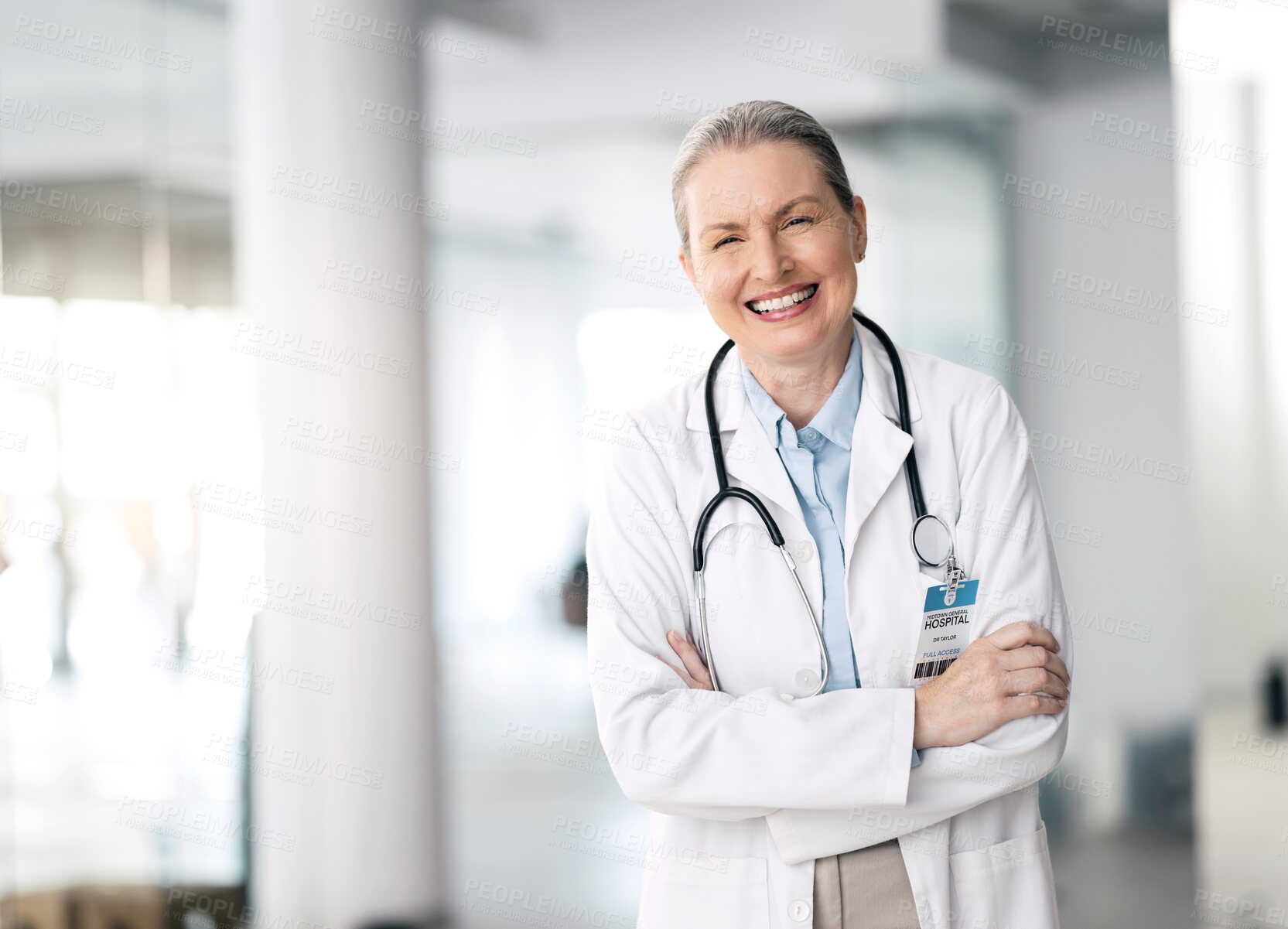 Buy stock photo Doctor, woman and happy with arms crossed in hospital, standing and smile for medicine. Mature, person and healthcare for research, treatment or surgery with specialist in cardiology with stethoscope