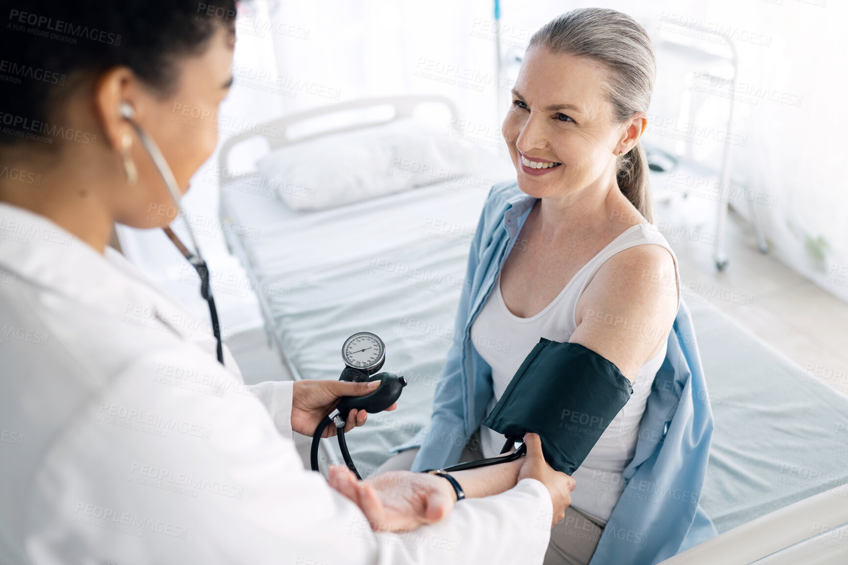 Buy stock photo Doctor, patient and blood pressure for medical appointment, checkup or visit at hospital. Happy woman, surgeon or nurse helping customer or client for monitoring heart rate at healthcare clinic