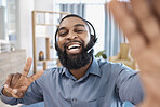 Call center, selfie and portrait of customer service consultant in the office with peace sign. Happy, smile and African male telemarketing agent taking a picture with headset in the modern workplace.