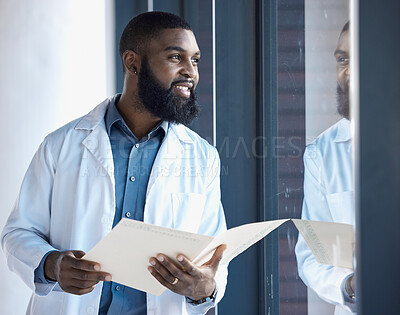 Buy stock photo Doctor, black man and thinking of healthcare information, paperwork or documents by window in building with smile. Person, professional or person thoughtful of notes or charts on paper with ideas