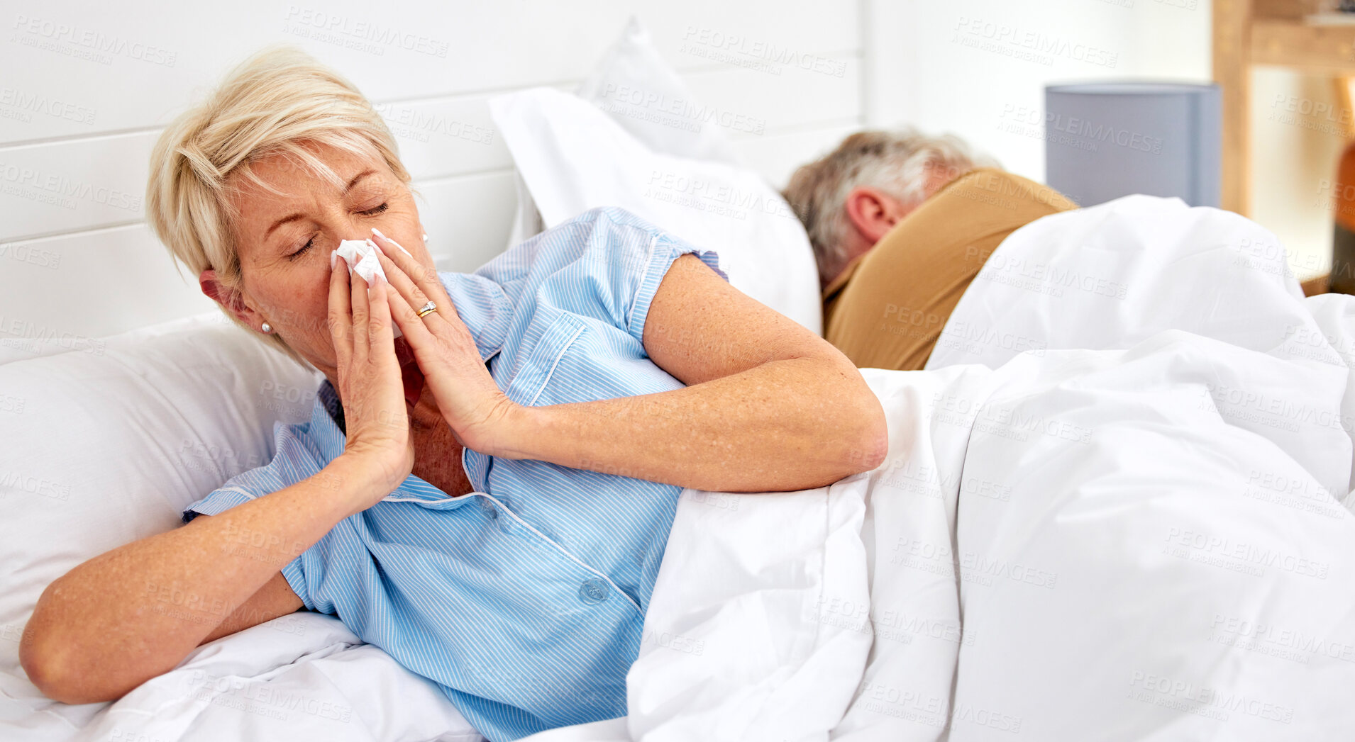 Buy stock photo Blowing nose, couple or sick old woman in bed with husband with flu virus, cold or health problem. Sneeze, mature or senior person with tissue toilet paper, fever or allergy illness in home bedroom