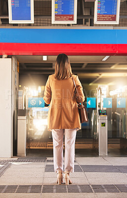 Walking, back and a woman at a station for a train, travel and entrance at a platform. Standing, waiting and a person entering a subway or gate for transportation, public traveling or transit