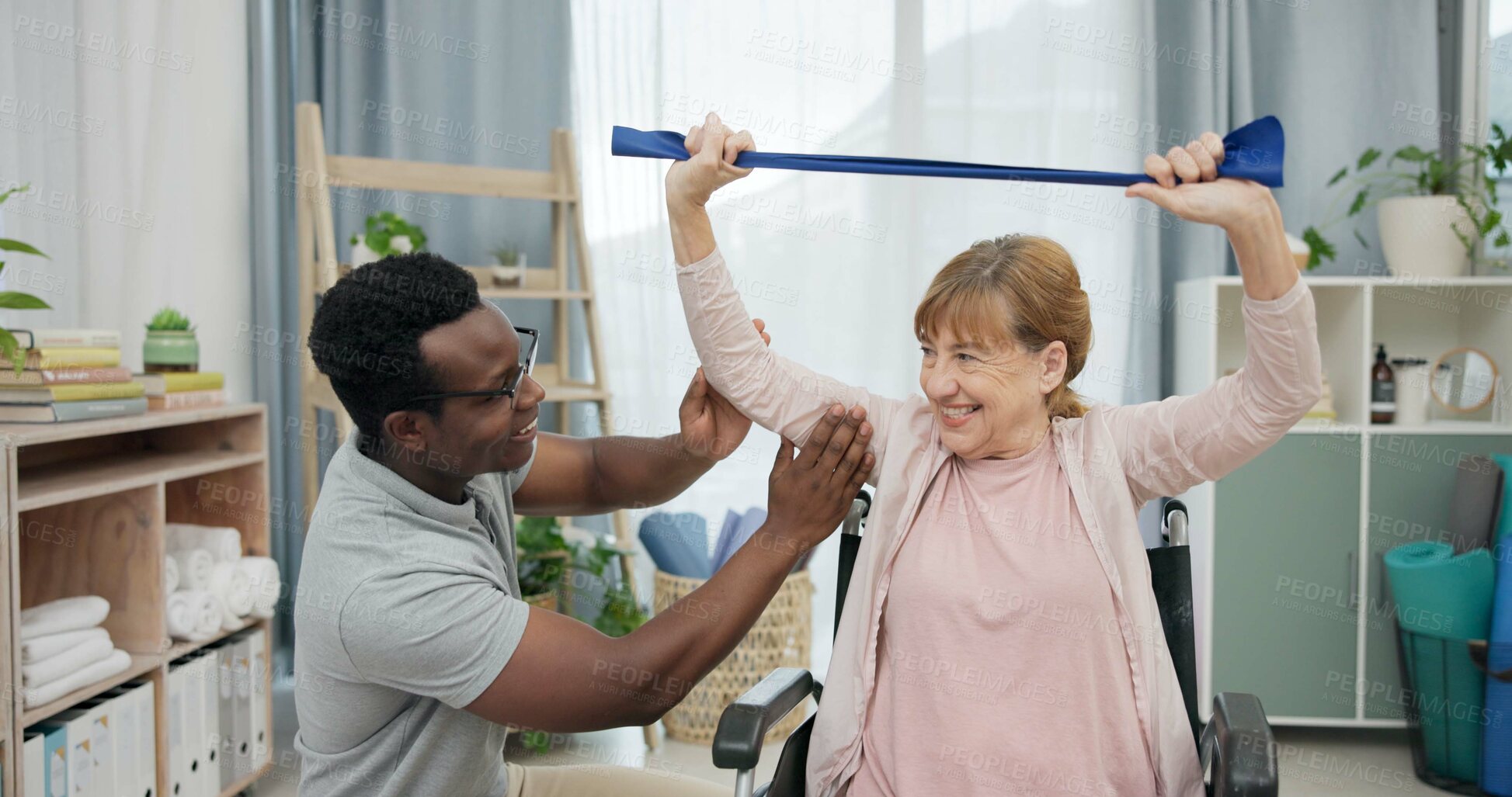 Buy stock photo Happy senior woman with disability, physiotherapist and stretching band for muscle rehabilitation at chiropractor. Physical therapy, medical support and patient in wheelchair smile for recovery help