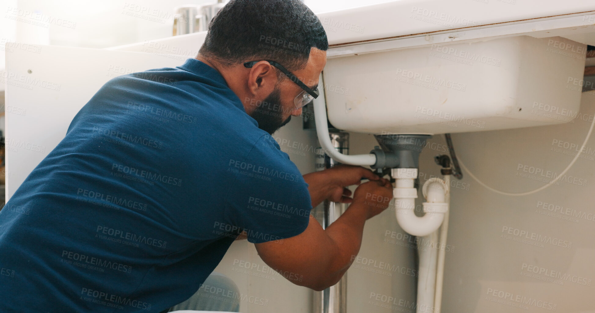 Buy stock photo Plumber black man, kitchen and sink maintenance with tools, focus and pipe repair for drainage in home. Entrepreneur handyman, plumbing expert or small business owner in house for fixing water system