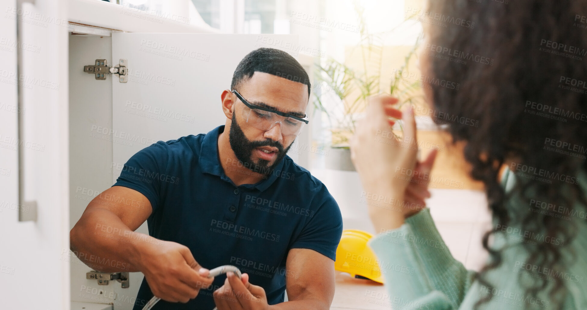 Buy stock photo Plumber black man, woman and maintenance talk in kitchen for sink pipe with customer support in home. Entrepreneur handyman, plumbing or small business owner with consulting for fixing water system