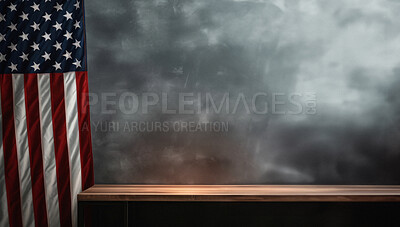 American flag hanging on the side of grey wall with table in front of wall. Background copy space.