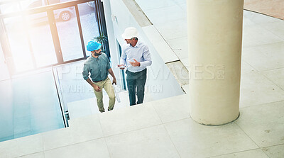 Buy stock photo Shot of two architects doing an inspection of their site while wearing hardhats