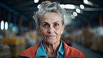 Confident serious mature older woman in warehouse. Worker, supervisor and industrial contractor at project