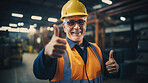 Confident mature older man with hardhat in shipping warehouse showing thumbsup at camera