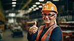 Confident mature older woman with hardhat in shipping warehouse showing thumbsup at camera