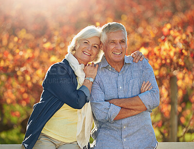 Buy stock photo Portrait of a smiling senior couple standing together in front of a vineyard in the autumn
