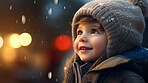 Toddler child cheerfully looking up at falling snow in winter or christmas season