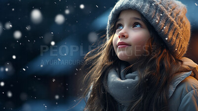 Toddler child cheerfully looking up at falling snow in winter or christmas season