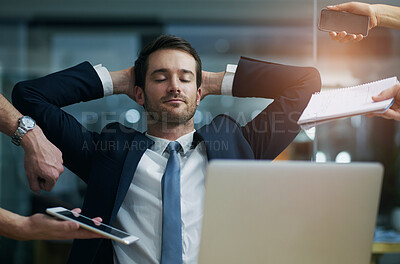 Buy stock photo Shot of a businessman sitting calmly at his desk while surrounded by demanding colleagues in an office
