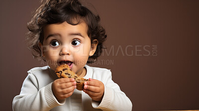 Toddler eating a piece of bread or cake. Messy baby girl eating bread or snack