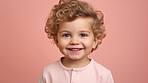 Portrait of a toddler posing against a pink background. happy smiling boy