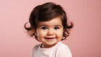 Portrait of a toddler posing against a pink background. happy smiling girl