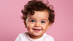 Portrait of a toddler posing against a pink background. happy smiling boy