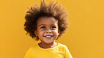 Portrait of a toddler posing against a yellow background. happy smiling girl