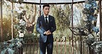 Groom, waiting and man in wedding or ceremony at alter with anxiety, stress or nervous energy for marriage or commitment. Formal, suit and excited person standing in aisle with flowers and nature