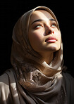 Young muslim woman lifting her head in prayer. Sunlight on her face. Religion concept.