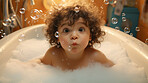 Toddler bathes in bathtub with foam and bubbles. Happy baby bath time