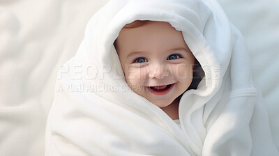 Portrait of a happy baby wrapped in a towel or blanket. Toddler smiling after bath time