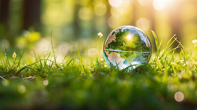 Glass globe on grass in a forest. Sustainable environment and Earth Day concept