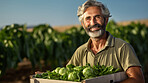 Farmer holding a box or crate with fresh organic vegetables or agricultural product